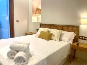 a bedroom with a white bed with towels on it at Pepitas House in Valencia