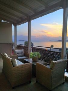 a patio with chairs and a table with a view of the ocean at House in riviera lagonisi in Kalívia Thorikoú