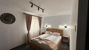 a bedroom with a bed with two lamps and a window at Dream House in Făgăraş