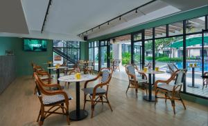 een restaurant met tafels, stoelen en ramen bij Holiday At Midhills Genting Highlands Free Wi-Fi in Genting Highlands