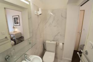 a bathroom with a toilet and a sink and a mirror at Brit Hotel Des Grands Hommes - Bordeaux Centre in Bordeaux