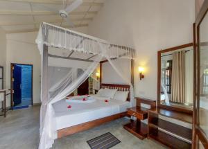 Un dormitorio con una cama blanca con dosel. en White Villa Goyambokka, en Tangalle 125 fotos más