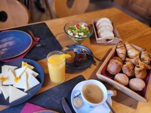 un tavolo con prodotti per la colazione e una tazza di caffè di Auberge le Mont-Gelé a Iserables