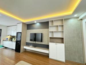 a kitchen with white cabinets and a tv on a wall at Love House - Tecco Elite Thai Nguyen in Thái Nguyên