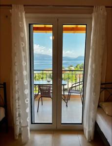 a sliding glass door with a view of the ocean at Valedina Rooms in Nikiana