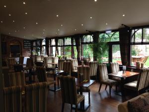 a dining room with tables and chairs and windows at Bowburn Hall Hotel in Durham
