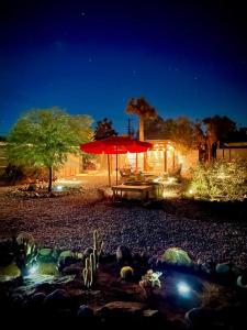 a patio with an umbrella and a pond at night at The Desert Shire Stargazing,Cold Plung & LargeSpa in Yucca Valley