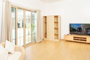 uma sala de estar com uma televisão de ecrã plano e um sofá em Seapearl of Alona em Panglao City