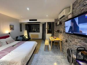 パタヤ・サウスにあるFurnished Studio Near The Beachのベッドと薄型テレビがあるホテルの部屋