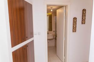 a bathroom with a door leading into a bathroom with a sink at One Bedroom Apartment - Hawana Salalah in Ţāqah