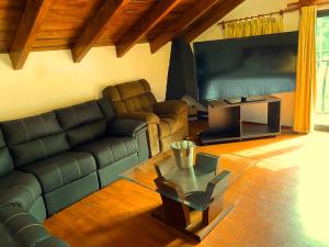 a living room with a couch and a large screen tv at Alojamiento tipo Cabaña, rodeado de Bosque in Mexico City