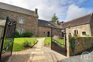 an entrance to an old stone house with a black gate at Rubis in Troguéry