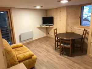 a living room with a table and a couch at FLUMET , Appartement Espace Diamant in Flumet +9 photos
