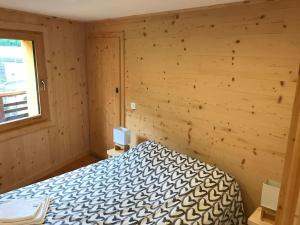 a bedroom with a bed in a wooden room at FLUMET , Appartement Espace Diamant in Flumet