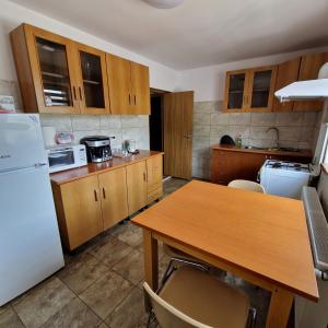 a kitchen with a table and a white refrigerator at Casa Diana in Curtea de Argeş +7 photos