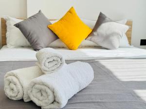 a bed with towels on it with pillows at 417I1 Gray and Yellow apartment Sholpan city in Almaty