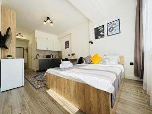 a bedroom with a large bed and a kitchen at 417I1 Gray and Yellow apartment Sholpan city in Almaty +17 photos