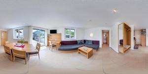 a living room with a couch and a table at Haus Emilia am Faschinajoch in Fontanella