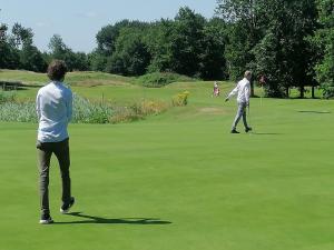 two men playing golf on a golf course at Naomi in Steendam