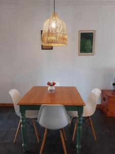 un tavolo da pranzo con sedie bianche e una gabbia per uccelli di Graskop Cottage a Graskop