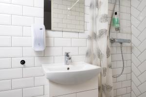 un bagno bianco con lavandino e doccia di Pärnu Old Town Apartment with Patio a Pärnu Altre 16 foto