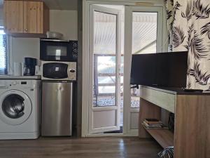 a kitchen with a washing machine and a microwave at Mobil-home in Foix