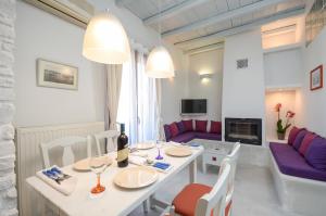 uma sala de estar com uma mesa e cadeiras e um sofá em Santa Katerina Apartments & Studios em Naxos Chora