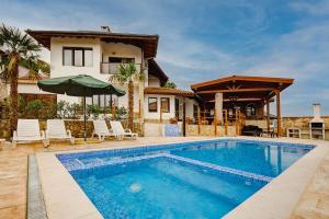 a villa with a swimming pool and a house at Guest House Andrea in Rogachevo