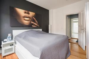 a bedroom with a bed with a picture on the wall at TOP 2 Zimmer Altbauwohnung in Kiel Mitte 24-7 Check In in Kiel