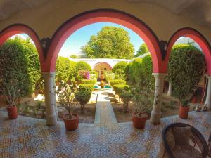 an archway with potted plants in a courtyard at Hacienda Santa Cruz Del Fuerte in El Fuerte