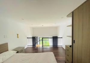 a bedroom with white walls and a bed and wooden floors at KSI-HOME Đà Lạt in Khu Chi Lăng