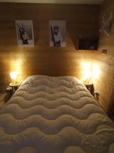a large bed in a bedroom with two lamps at Le Cocon des Carroz, au centre de la station et proximité des pistes, apt 4 pers in Arâches-la-Frasse