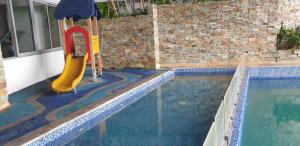 a swimming pool with a slide next to a swimming pool at Tripleview luxurious eton baypark manila in Manila