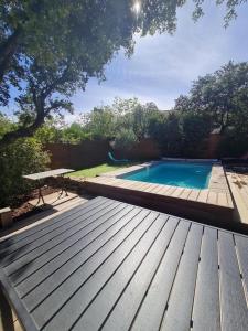 a swimming pool sitting next to a wooden deck at Gîte location de vacances : G2735 in Saint-Maximin-la-Sainte-Baume