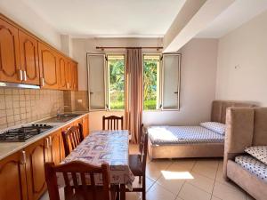 a kitchen with a table and a couch and a dining room at Onis Sea View Apartments in Orikum