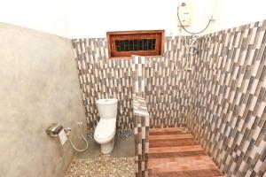 a bathroom with a white toilet in a shower at Elephant Trio Sigiriya in Sigiriya