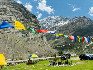 a group of chairs and flags in a field with mountains at Kinzom Valley Camps in Jispa