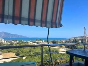 a view of the ocean from a balcony with an umbrella at Onis Sea View Apartments in Orikum