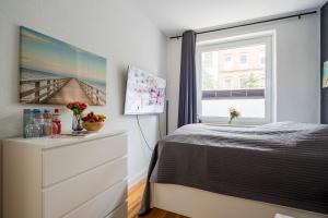 a bedroom with a bed and a window at Schicke Altbauwohnung in Kiel Mitte 24-7 Check In in Kiel