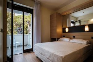 里乔内Augustus Hotel Riccione的一间带大床和大窗户的卧室 更多37张照片
