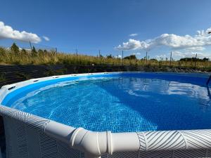 a large blue swimming pool sitting on a white chair at Domki Maju Maj in Darłowo