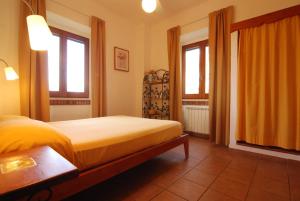 a bedroom with a bed and two windows at Villa Prato Agriturismo in Sperlonga