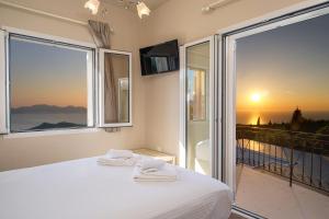 a bedroom with a bed and a large window at Panoramic Sunset in Kothréas