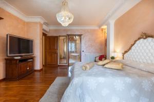una camera da letto con un letto, una TV e un lampadario a braccio di La Casa di Tonina a Quartu SantʼElena