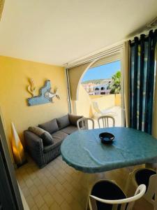 a living room with a table and a couch at T2 Mer et Soleil avec Terrasse in Sète