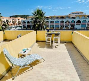 a patio with a table and chairs on a balcony at T2 Mer et Soleil avec Terrasse in Sète