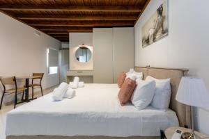 una camera da letto con un grande letto bianco con cuscini bianchi di Lindian Villas a Líndos