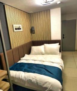 a bedroom with a large bed with blue and white sheets at Nani City Hotel in Zürich
