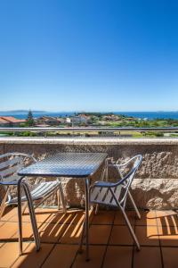 a table and two chairs on a balcony at Apartamentos Eira Do Mar Sanxenxo in Aios