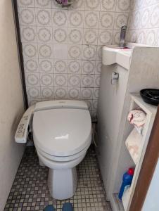 a small bathroom with a toilet and a sink at ビジネスホテルみやこ in Higashi-osaka